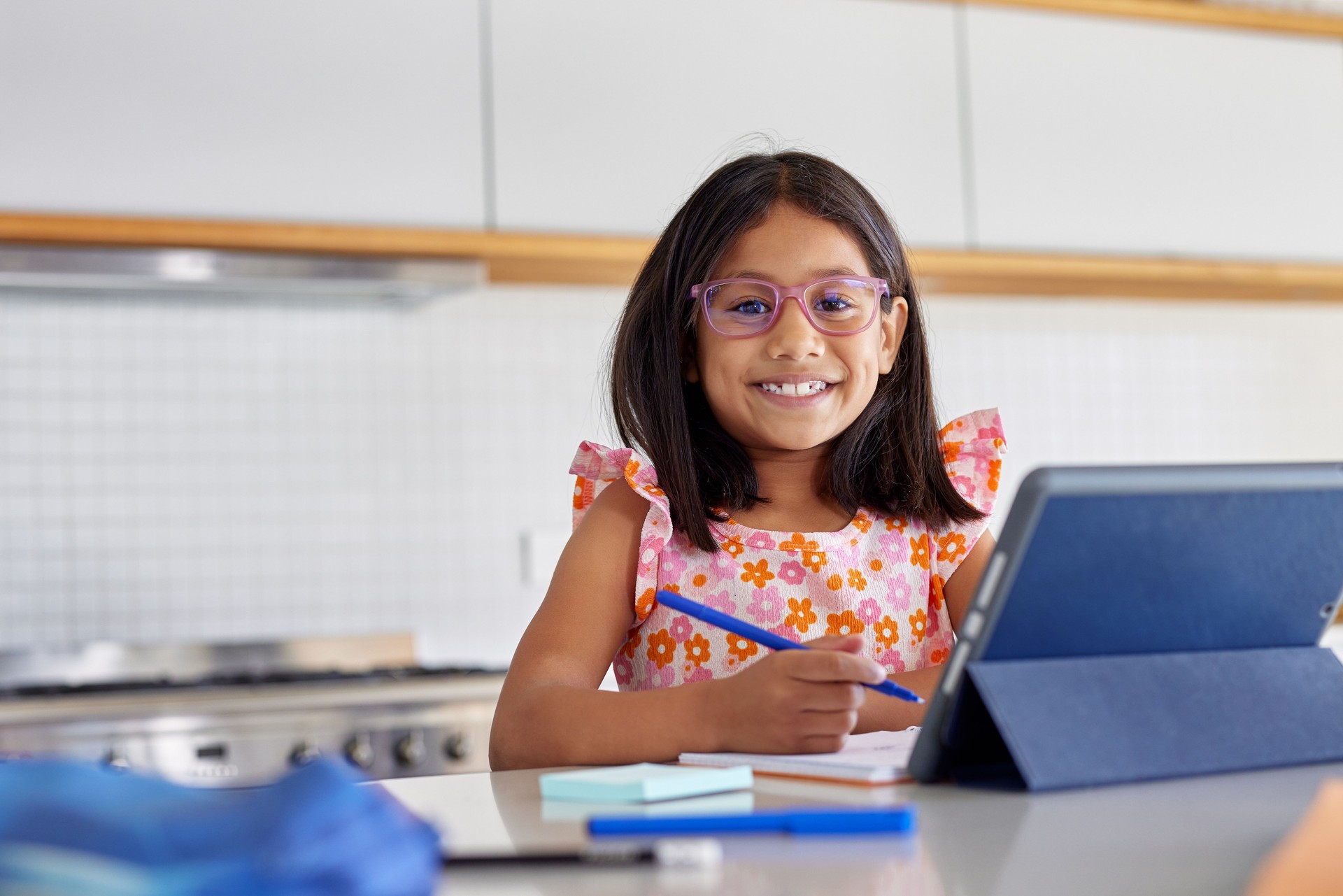 Portrait of little middle eastern girl studying at home on digital tablet